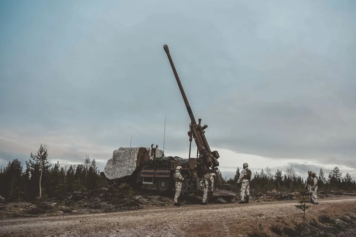 Des artilleurs français autour d’un canon CAESAR installé sur une piste forestière en Finlande.